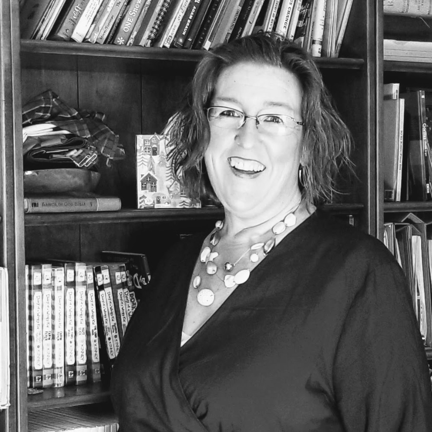 Headshot Heather Medley smiling near bookshelf